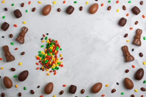 Chocolate easter eggs, rabbits, casks and sweets on concrete background Stock Photos