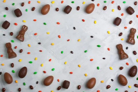 Chocolate easter eggs, rabbits, casks and sweets pattern on concrete backgrou Stock Photos