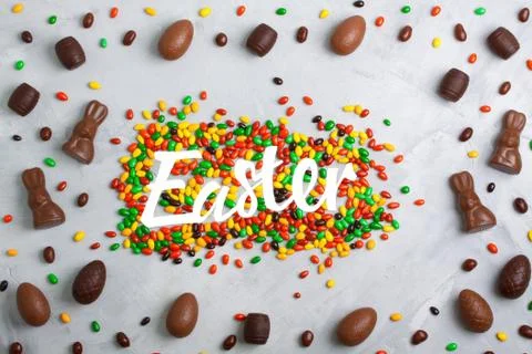 Chocolate easter eggs, rabbits, casks and sweets on concrete background Stock Photos