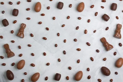 Chocolate easter eggs, rabbits, casks, brown sweets on concrete background Foto stock