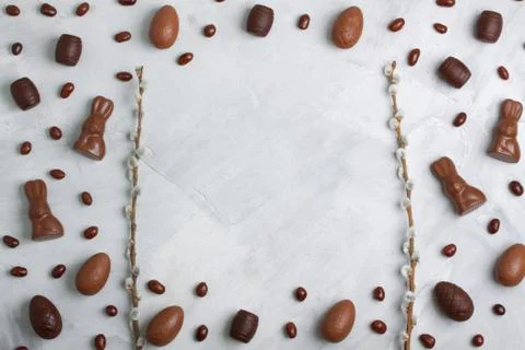 Chocolate easter eggs, rabbits, casks, green sweets on concrete background Stock Photos