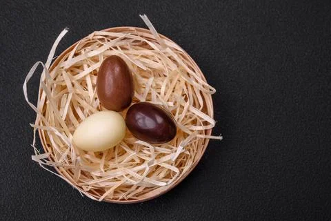 Chocolate Easter hen and eggs in a nest with straw Stock Photos
