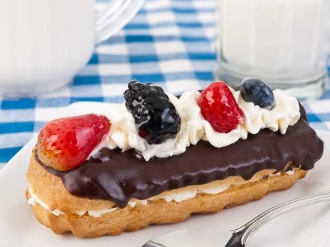 Chocolate eclair with berries and whipped cream on top Stock Photos