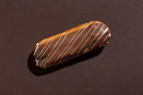 Chocolate eclair on a brown background Stock Photos