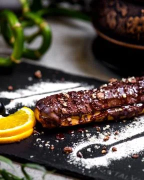 Chocolate eclair with lemon slice Stock Photos