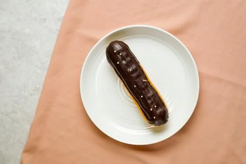 Chocolate Eclair served in plate isolated on napkin top view of cafe baked .. Stock Photos