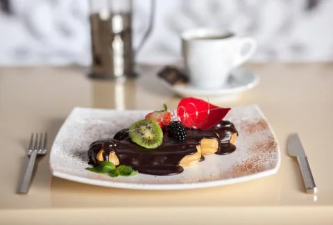 Chocolate eclairs with coffee Stock Photos