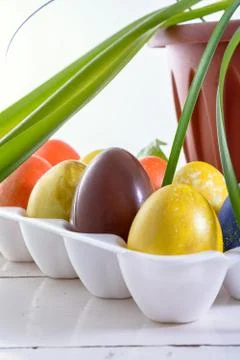 Chocolate egg among colored easter eggs. Stock Photos