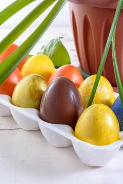 Chocolate egg among colored easter eggs. Stock Photos