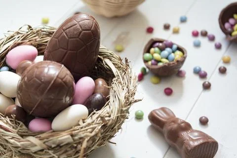 Chocolate eggs and easter almonds on bird nest, chocolate bunny and sweets on Foto stock