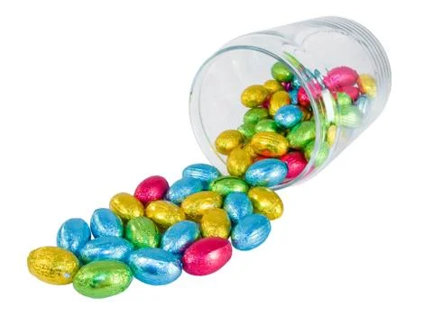 Chocolate eggs spilling out of a jar. Traditional Easter sweet. Stock Photos