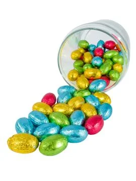Chocolate eggs spilling out of a jar. Traditional Easter sweet. Stock Photos
