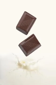 Chocolate falling into milk Stock Photos