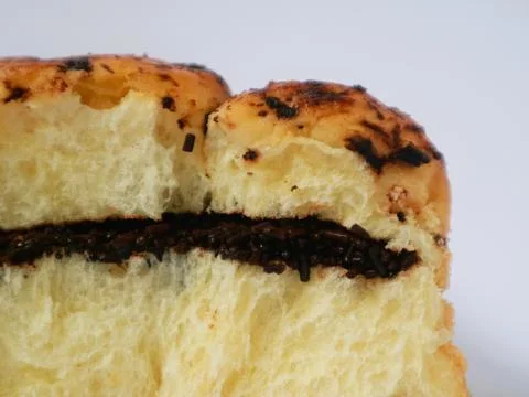 A chocolate-filled bread bun or pastry, isolated on white background Stock Photos