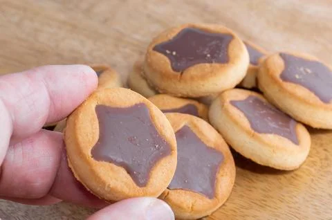 A chocolate-filled cookie in hand Stock Photos