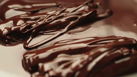 The chocolate flows into the chocolate in two streams Stock Footage 161077249