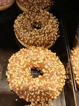 Chocolate glazed donuts with chopped nuts Stock Photos