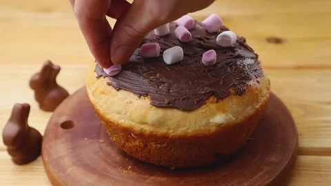 Chocolate glazed easter pie decorating with marshmallows on wooden board. Stock Footage 129777151