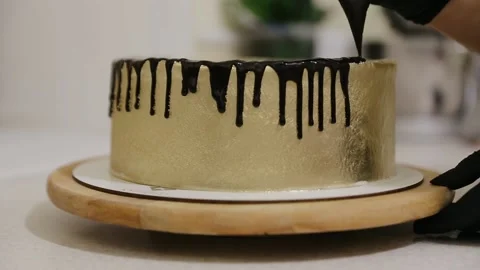 Chocolate icing on the cake. Golden cake covered with chocolate and cream Stock Footage 134681206
