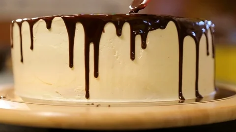 Chocolate icing on the cake. White cake covered with chocolate and cream Stock Footage 82087184