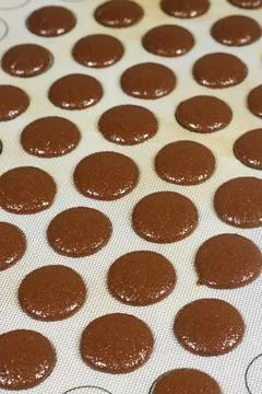 Chocolate Macaron Shells Piped on Silicone Baking Mat Ready for Baking in a Prof Stock Photos