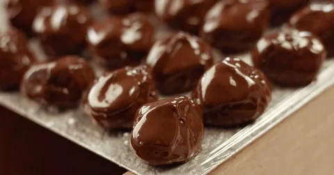 Chocolate master in his factory makes a truffles. Chocolate truffles making of Video stock 77909289