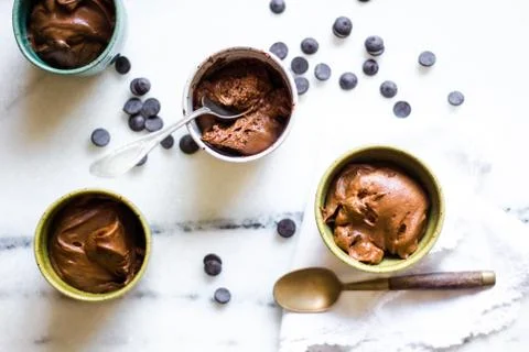 Chocolate mousse on tiny cups and marble background top view Stock Photos