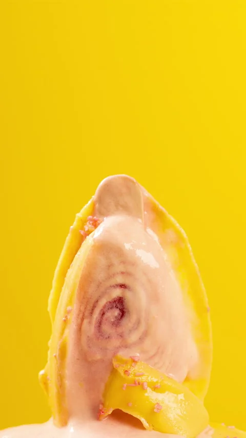 Chocolate outer yellow popsicle melting on yellow background timelapse at ver Stock Footage 194658028