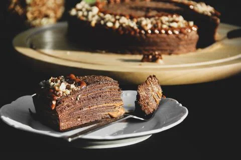 Chocolate pancake cake with nuts. Pie close-up. Cake on black background Foto stock