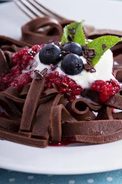 Chocolate pasta with raspberry sauce, whipped cream and fresh berries Stock Photos