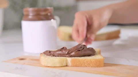 Chocolate paste. Chocolate hazelnut spread spread on fresh bread. Sweet toast Stock-Footage 196089066