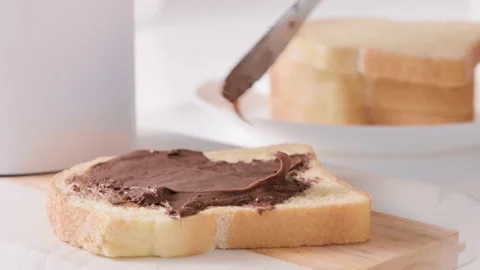 Chocolate paste. Chocolate hazelnut spread spread on fresh bread. Sweet toast Stock Footage 196118094