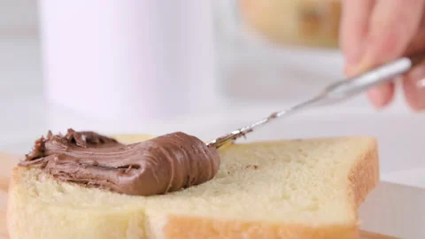 Chocolate paste. Chocolate hazelnut spread spread on fresh bread. Sweet toast Stock Footage 197346597