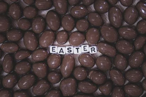 Chocolate peanuts eggs with the word Easter in white and black plastic square Stock Photos