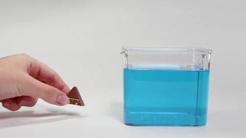 Chocolate Piece Sinking in Blue Liquid Experiment Video stock 308227466