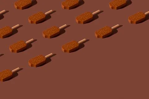 Chocolate popsicles pattern on a brown background. Minimal ice cream layout. Stockfoto's