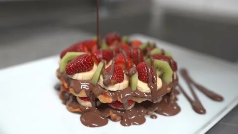 Chocolate is poured on waffles Stock Footage 196193430