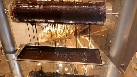 Chocolate pouring from machine with roller. Manufacturing chocolate. 스톡 동영상 100110900