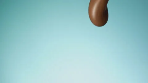 Chocolate pouring over flat background Stock Footage 149003462
