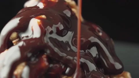 Chocolate pouring on top of a walnut dessert, rotate. Stock Footage 166111908