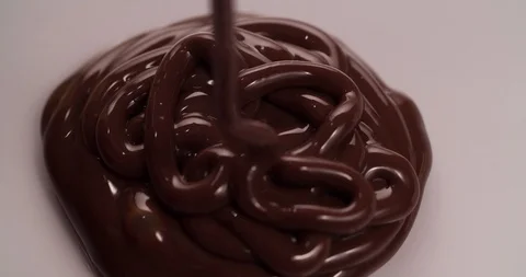 Chocolate is pouring on white surface Close up Macro shot Stock Footage 108815143