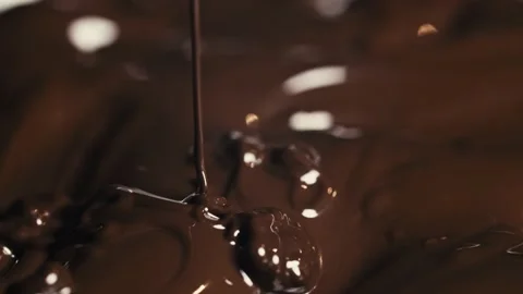 Chocolate pours into a pool of chocolate. Stock Footage 142068297