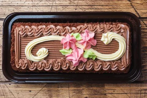 Chocolate rectangular cake decorated with cream roses. Sweet food is a conf.. 스톡 사진