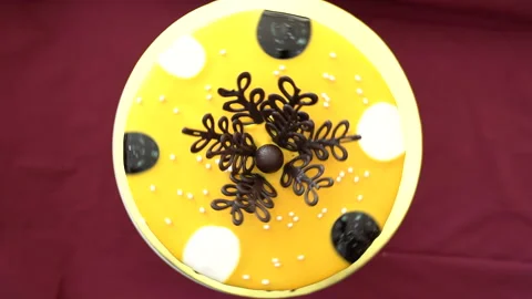 Chocolate round cake with black pattern and yellow decoration Stock Footage 234825563