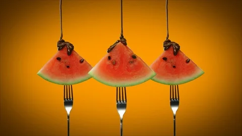 Chocolate sauce pouring over triangles of watermelon slices on dessert forks Stock Footage 125433006