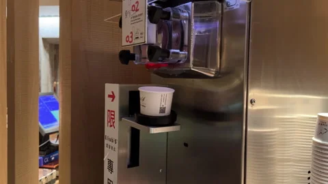 Chocolate Soft Serve Delight: Automatic Ice Cream Machine in Action at Buffet Stock Footage 303760778