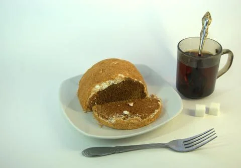 Chocolate sponge cake with a sprinkle on a ceramic plate and a fork nearby, a Stock Photos