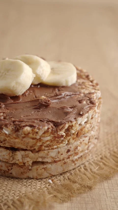 Chocolate Spread Rice Cake With Butter Slice On Rustic Wooden Surface, Close-Up Stock Footage 338151771