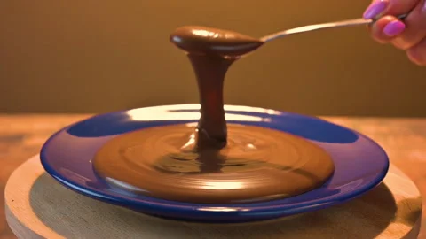Chocolate spread with a spoon on a rotating blue plate Stock Footage 152807867