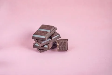 Chocolate stack on pink background. Stock Photos